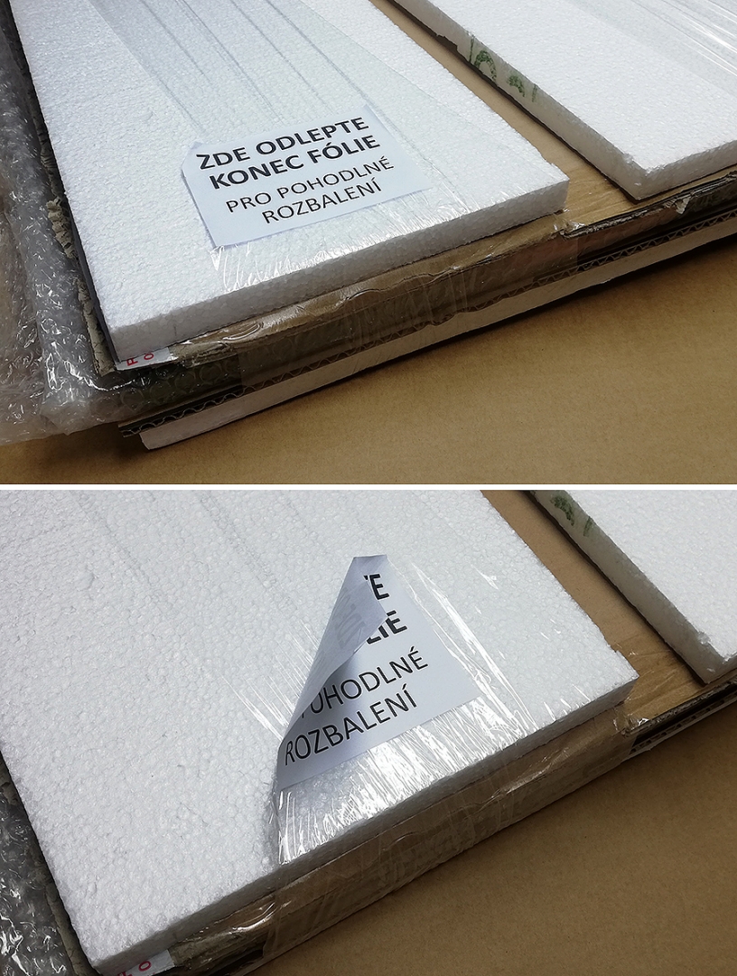 Zabalený fotoobraz do kartonu a polystyrenu se samolepkou označující konec fólie.